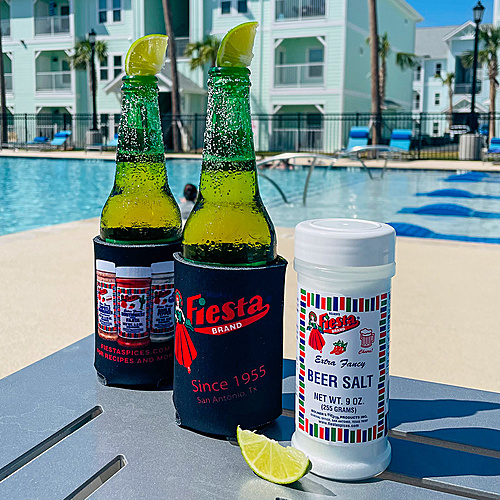 Fiesta Brand Beer Salt with lime wedge and two beers by the pool